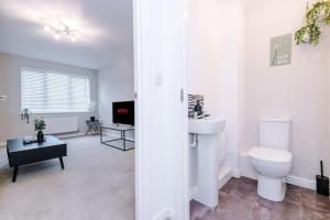 een witte badkamer met een toilet en een wastafel bij Lovely three bed home Manchester in Heywood