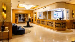 a salon with a bar in the middle of a lobby at Hotel Le Châtelain in Brussels