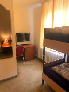 a room with a bedroom with a television and a desk at Monteurzimmer Riesa in Riesa