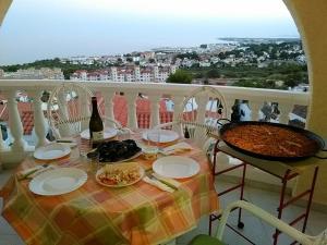 a table with plates of food and a bottle of wine at Chalet en Alcossebre in Alcossebre