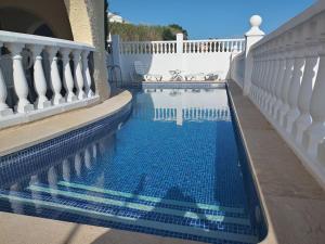 a swimming pool with a white fence and a blue pool at Chalet en Alcossebre in Alcossebre