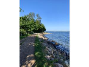 un camino a lo largo de la orilla de un cuerpo de agua en Ferienwohnung Yachthafen - Fördeblick, Glück 2, en Glücksburg