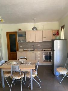 een keuken met een tafel met stoelen en een koelkast bij Casa Vacanze Rinaldi in Mattinata