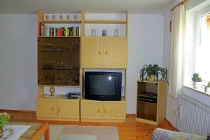 a living room with a wooden entertainment center with a television at Haus Rita in Thurmansbang