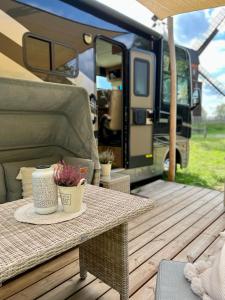 a table on a wooden deck with an rv at Camper XXL in Parey