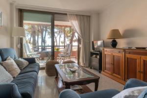 een woonkamer met een bank en een tafel bij AT053 Els Pins, primera línea con piscina, airco in Torredembarra