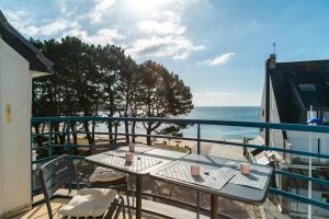 ein Balkon mit Tisch und Stühlen und dem Meer in der Unterkunft Penn Odet - vue mer in Bénodet