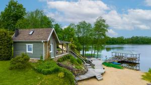 una pequeña casa con un muelle en un lago en Vila Terra Resort, en Girsteitiškis