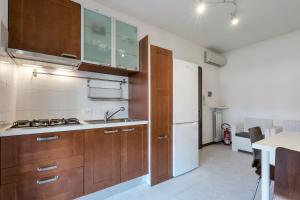 Terrazza di Leonardo - 2 bedrooms apartment في سان مارتينو ديلا باتاجليا: مطبخ بدولاب خشبي وثلاجة بيضاء