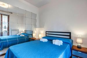 Terrazza di Leonardo - 2 bedrooms apartment في سان مارتينو ديلا باتاجليا: سريرين في غرفة نوم مع ملاءات زرقاء