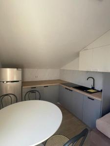 een kleine keuken met een witte tafel en stoelen bij Apartments Beachwalk Heaven Milica in Srima