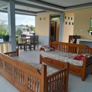 two beds in a room with a balcony at The Balbina House in Labuan Bajo