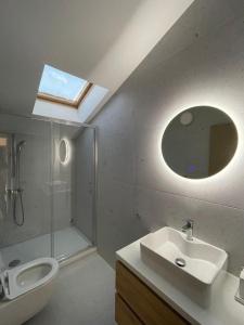 een badkamer met een wastafel, een toilet en een spiegel bij Apartments Beachwalk Heaven Milica in Srima