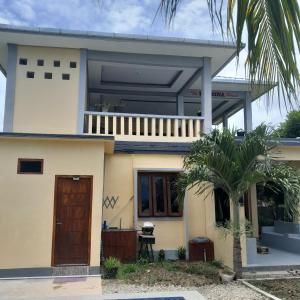 a house with a palm tree in front of it at The Balbina House in Labuan Bajo