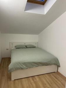 een bed in een witte slaapkamer met een wit plafond bij Apartments Beachwalk Heaven Milica in Srima