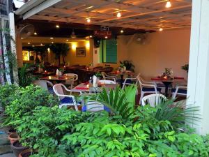 a restaurant with tables and chairs and plants at Paradise Inn in Karon Beach