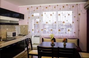 a kitchen with a table and chairs in front of a window at ,,Дироси'' in Sveti Vlas