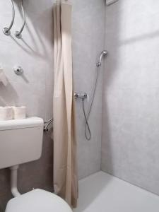 a bathroom with a shower with a toilet and a shower curtain at Apartmani Babić in Neum +10 photos