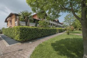 un edificio con una siepe di fronte a un cortile di Terrazza di Leonardo - 2 bedrooms apartment a San Martino della Battaglia