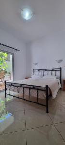 uma cama num quarto branco com uma estrutura de cama em Anesis em Diafánion