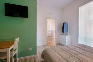 a bedroom with a bed and a desk and a television at B&B Bentivogli in Bologna