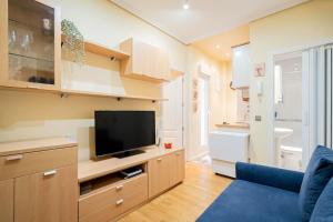 salon z telewizorem i niebieską kanapą w obiekcie Tranquilo apartamento Pacífico/Ciudad de Barcelona w Madrycie