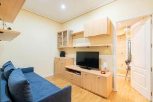salon z niebieską kanapą i telewizorem w obiekcie Tranquilo apartamento Pacífico/Ciudad de Barcelona w Madrycie