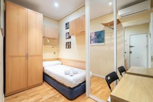 mały pokój z łóżkiem i szklanymi drzwiami w obiekcie Tranquilo apartamento Pacífico/Ciudad de Barcelona w Madrycie