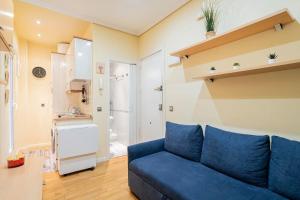 salon z niebieską kanapą i kuchnią w obiekcie Tranquilo apartamento Pacífico/Ciudad de Barcelona w Madrycie