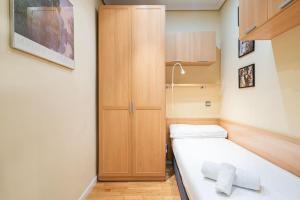 mały pokój z łóżkiem i drewnianą szafką w obiekcie Tranquilo apartamento Pacífico/Ciudad de Barcelona w Madrycie