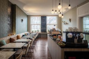 a restaurant with a row of tables and chairs at Hotel Augustyn Brugge in Bruges
