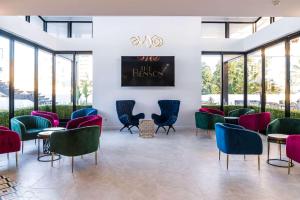 a lobby with colorful chairs and tables in a building at The Benson Hotel in Cairns