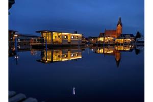 巴特Hausboot Fjord Vela mit Biosauna in Barth的一群船在晚上坐在水面上