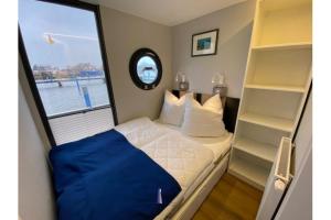 a small bedroom with a bed and a window at Hausboot Fjord Vela mit Biosauna in Barth in Barth