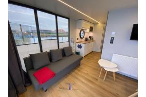 uma sala de estar com um sofá e uma mesa em Hausboot Fjord Vela mit Biosauna in Barth em Barth