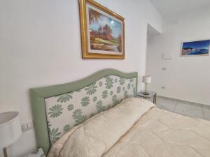 1 dormitorio con 1 cama y una foto en la pared en Tina’s Room en Santa Maria di Castellabate