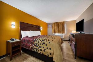 a hotel room with a bed and a flat screen tv at Econo Lodge San Antonio near SeaWorld - Medical Center in San Antonio