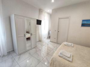 Habitación blanca con cama y baño. en Tina’s Room en Santa Maria di Castellabate