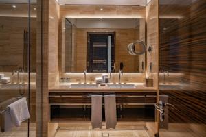 une salle de bain avec un lavabo et un miroir dans l'établissement Hyde Hotel Dubai, à Dubaï