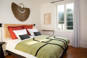 ein Schlafzimmer mit einem großen Bett und einem Fenster in der Unterkunft Villa L'Anse in Étretat