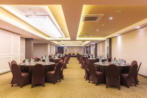 ein Konferenzraum mit Tischen und Stühlen in der Unterkunft Great Diponegoro Hotel Surabaya in Surabaya