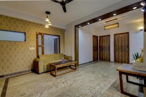 a living room with a couch and a table at Treebo Trend Sai Village Manesar in Gurgaon