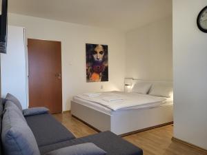 ein kleines Zimmer mit einem Bett und einem Sofa in der Unterkunft Apartmány EMMA in Podhájska