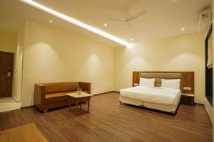 a hotel room with a bed and a couch at The Amber hotel in Ambikāpur