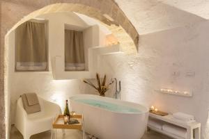 a white bathroom with a tub and a sink at Bright Stone con Vasca Jacuzzi in Monopoli