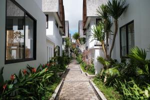 烏布的住宿－ASRI CINTA VILLA，两栋棕榈树建筑之间的人行道