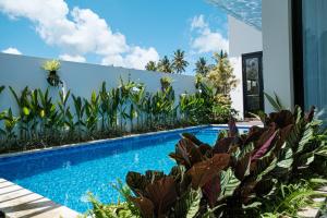 una piscina con piante accanto a un edificio di ASRI CINTA VILLA ad Ubud