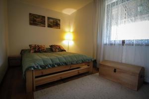 małą sypialnię z łóżkiem z oknem w obiekcie Chalupa Dejnowo w mieście Pilec