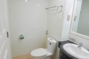 La salle de bains blanche est pourvue de toilettes et d'un lavabo. dans l'établissement Dương Hằng- Ocean Vista Sealinks, à Ấp Ngọc Hải