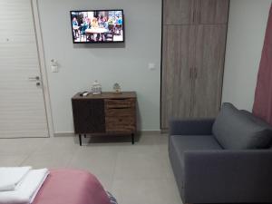 a living room with a couch and a tv on the wall at Bella Luxury Suite II in Paralia Katerinis